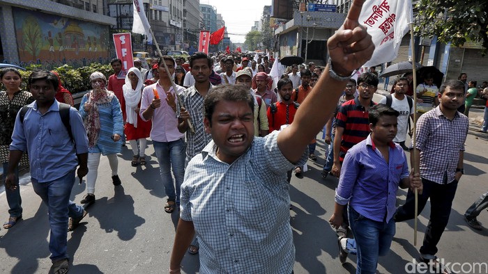 People walk past an overturned mobile urinal during a demonstration by members of the Jat community in Bahadurgarh in Haryana , India, February 21, 2016. India deployed thousands of troops in a northern state on Sunday to quell protests that have severely hit water supplies to Delhi, a metropolis of more than 20 million, forced factories to close and killed 10 people. REUTERS/Adnan Abidi