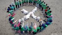 Sejumlah aktivis berfoto dengan tumpukan sampah yang telah dimasukan ke dalam karung. (Afriadi Hikmal/Greenpeace)