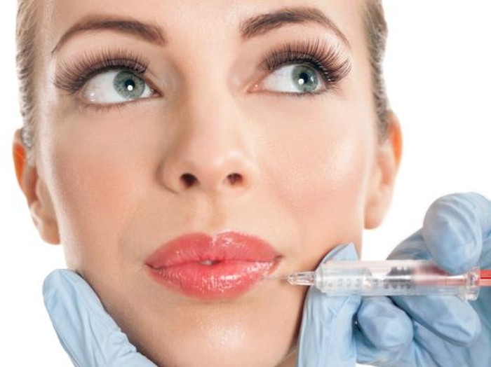 Beautiful woman gets an injection in her lips.