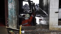 Petugas naik ke lantai 2 rumah warga untuk memadamkan api.