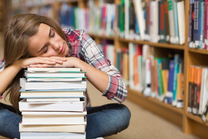 wanita tidur cover Sleeping student sitting on library floor leaning on pile of books