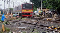 Seorang pedagang tetap menjajakan dagangannya di pinggir rel saat Commuter Line lewat. Pool/Al Fanny Panestika/detikFoto.