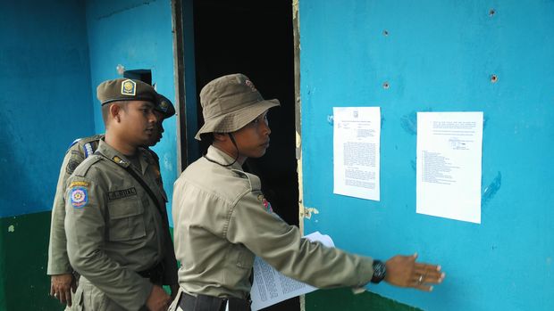 Petugas menempel surat peringatan penertiban Kalijodo.