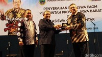 Gubernur Jawa Barat Ahmad Heryawan (tengah) didampingi Wakil Gubernur Jawa Barat Deddy Mizwar (kiri) berjabat tangan dengan Direktur Bisnis Regional Jawa Bagian Tengah PLN Nasri Sebayang (kanan) usai penyerahan beasiswa kepada mahasiswa di enam perguruan tinggi di Jawa Barat. Pool/Agus Trimukti/Humas PLN.