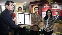 Menteri Hukum dan HAM Yasonna H Laoly memberikan sertifikat pendaftaran merek pesawat televisi buatan Muhammad Kusrin asal Karanganyar, Jawa Tengah.