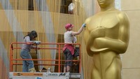 Para kru mempersiapkan patung Oscar yang berdiri di pintu kedatangan red carpet. Kevork Djansezian/Getty Images/detikFoto.