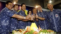 Presdir BCA Jahja Setiaatmadja bersama jajaran direksi mengacungkan jempol di atas tumpeng.