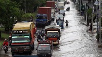 Kendaraan mengantre di jalan yang tergenang.