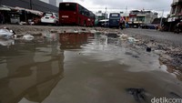 Jalanan di terminal tampak hancur dan menjadi genangan air kala hujan menyapa. 