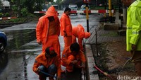 Mereka membersihkan saluran-saluran air yang mampet agar genangan segera surut.