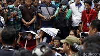 Beberapa warga menutupi kepalanya menggunakan koran untuk melindungi diri dari terik sinar matahari.