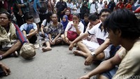 Warga duduk lesehan di tengah jalan untuk mengikuti doa bersama.