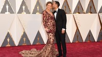 Aww, John mengecup sang istri saat berpose di red carpet. Jason Merritt/Getty Images/detikFoto.