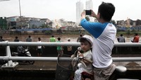 Sejumlah warga tampak mengabadikan moment penertiban kawasan Kalijodo tersebut dengan handphone mereka.