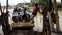 Perahu eretan ini mampu mengangkut penumpang dan kendaraan sepeda motor mereka.