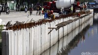 Pekerja menggunakan alat berat memasang tiang beton (sheet pile) di pinggiran Sungai, Kawasan Sunter, Jakarta, Rabu (2/3/2016).