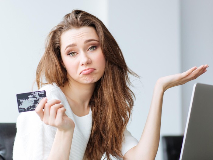 507961944 Sad woman with laptop and bank card