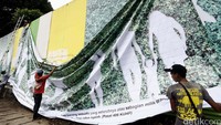 Salah satunya petugas memasang spanduk raksasa untuk menutupi dinding yang terlihat kumuh agar terlihat bersih dan rapi.
