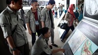 Risers melihat peta yang terkena dampak tsunami.