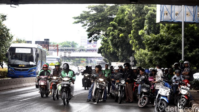 Hujan mengguyur kawasan Senayan, Jakarta, Jumat (4/3/2016) pagi. Hujan membuat banyak pengendara sepeda motor berteduh di kolong jembatan Senayan.
