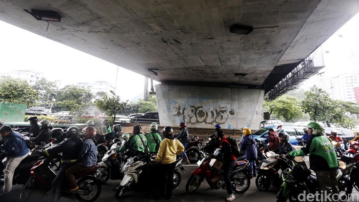 Hujan mengguyur kawasan Senayan, Jakarta, Jumat (4/3/2016) pagi. Hujan membuat banyak pengendara sepeda motor berteduh di kolong jembatan Senayan.