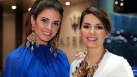 Dua model tersenyum ke arah kamera di dekat booth Maserati.