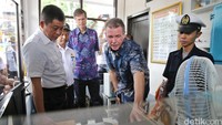Menhub Ignasius Jonan (kiri) mendapat penjelasan dari Presiden Honeywell Indonesia Alex Pollack (dua dari kanan) di ruang penjaga perlintasan kereta api.