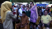 Beberapa wisatawan asing foto bersama dengan warga.