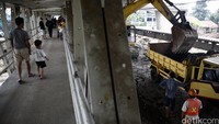 Warga menyaksikan pembongkaran jembatan.