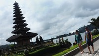 Wisatawan asing menikmati panorama Pura dan danau yang berhawa sejuk.