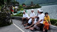 Beberapa orang umat Hindu Bali beristirahat sejenak di tepi danau usai melakukan ritual persembahan.
