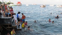 Yang bikin seru adalah puluhan orang, kebanyakan anak-anak yang berenang. Pantai Falajawa airnya jernih walau tampak beberapa sampah mengapung (Fitraya/detikTravel)