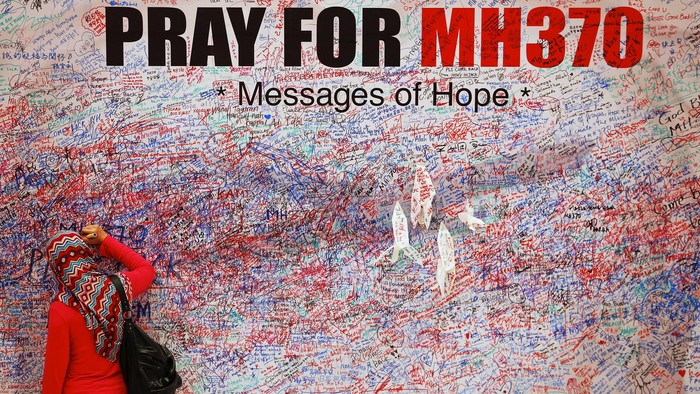 A woman leaves a message of support and hope for the passengers of the missing Malaysia Airlines MH370 in central Kuala Lumpur March 16, 2014. Police are combing through the personal, political and religious backgrounds of pilots and crew of the missing Malaysian jetliner, a senior officer said on Sunday, trying to work out why someone aboard flew the plane hundreds of miles off course. REUTERS/Damir Sagolj