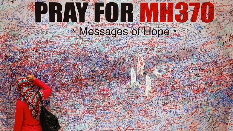 Tragedi MH370 A woman leaves a message of support and hope for the passengers of the missing Malaysia Airlines MH370 in central Kuala Lumpur March 16, 2014. Police are combing through the personal, political and religious backgrounds of pilots and crew of the missing Malaysian jetliner, a senior officer said on Sunday, trying to work out why someone aboard flew the plane hundreds of miles off course. REUTERS/Damir Sagolj
