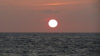 Bulatan sempurna matahari tampak jelas di garis horizon. Tidak seperti seringnya terjadi, dimana awan menutup di batas langit, kali ini matahari betul-betul jelas menyentuh garis horizon (Fitraya/detikTravel)