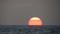 Perlahan dan anggun, bulatan itu menghilang di garis pertemuan laut dan langit. Wow! Sungguh sunset yang sempurna (Fitraya/detikTravel)