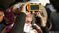 Warga melihat gerhana menggunakan alat khusus agar sinar matahari tidak langsung ke mata.
