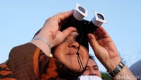 Risma menyaksikan detik-detik gerhana matahari.