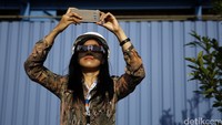 Seorang pekerja mengabadikan gerhana matahari sebagian.