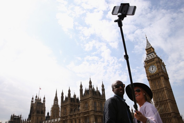 LONDON, ENGLAND - APRIL 16:  A couple take a selfie on Westminster Bridge with the Houses of Parliament in the background on April 16, 2015 in London, England. (Photo by Dan Kitwood/Getty Images)