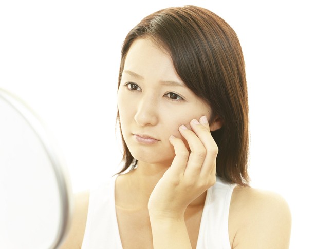 unhappy woman looking in the mirror