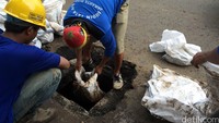 Tak cuma timbunan bungkus kabel yang memicu genangan di daerah ring 1. Gundukan lumpur yang sudah mengeras maupun yang masih lembek juga punya andil besar. Karena itu pekerja harian lepas dari Sudin Tata Air Pemkot Jakarta Pusat yang biasa disebut pasukan biru tak henti membersihkan lumpur yang bersarang di Jl Medan Merdeka Selatan. Bisma Alief/detikcom.