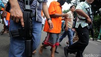Tangan tersangka tampak diborgol.