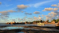 Pendar sunset yang tampak pada latar batu granit di Pantai Tanjung Tinggi yang semakin memperindah pemandangan. Tampak juga kapal yang tengah bersandar (Randy/detikTravel)