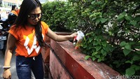 Seorang relawan mengambil sampah yang dibuang di area taman.