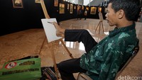 Penyandang disabilitas tengah melukis di sela-sela pameran.