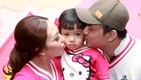 Ayu dan suaminya, Regi Datau mengecup pipi sang buah hati. Pool/Gus Mun/detikFoto.