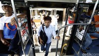 Seorang penumpang menaiki bus sekolah.