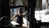 Pekerja memotong kayu gelondongan menjadi kayu lapis untuk bahan baku pembuatan furniture di Jakarta, Selasa (15/3/2016).