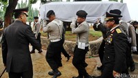 Personel Polri memanggul peti jenazah berbalut bendera merah putih ke pemakaman.